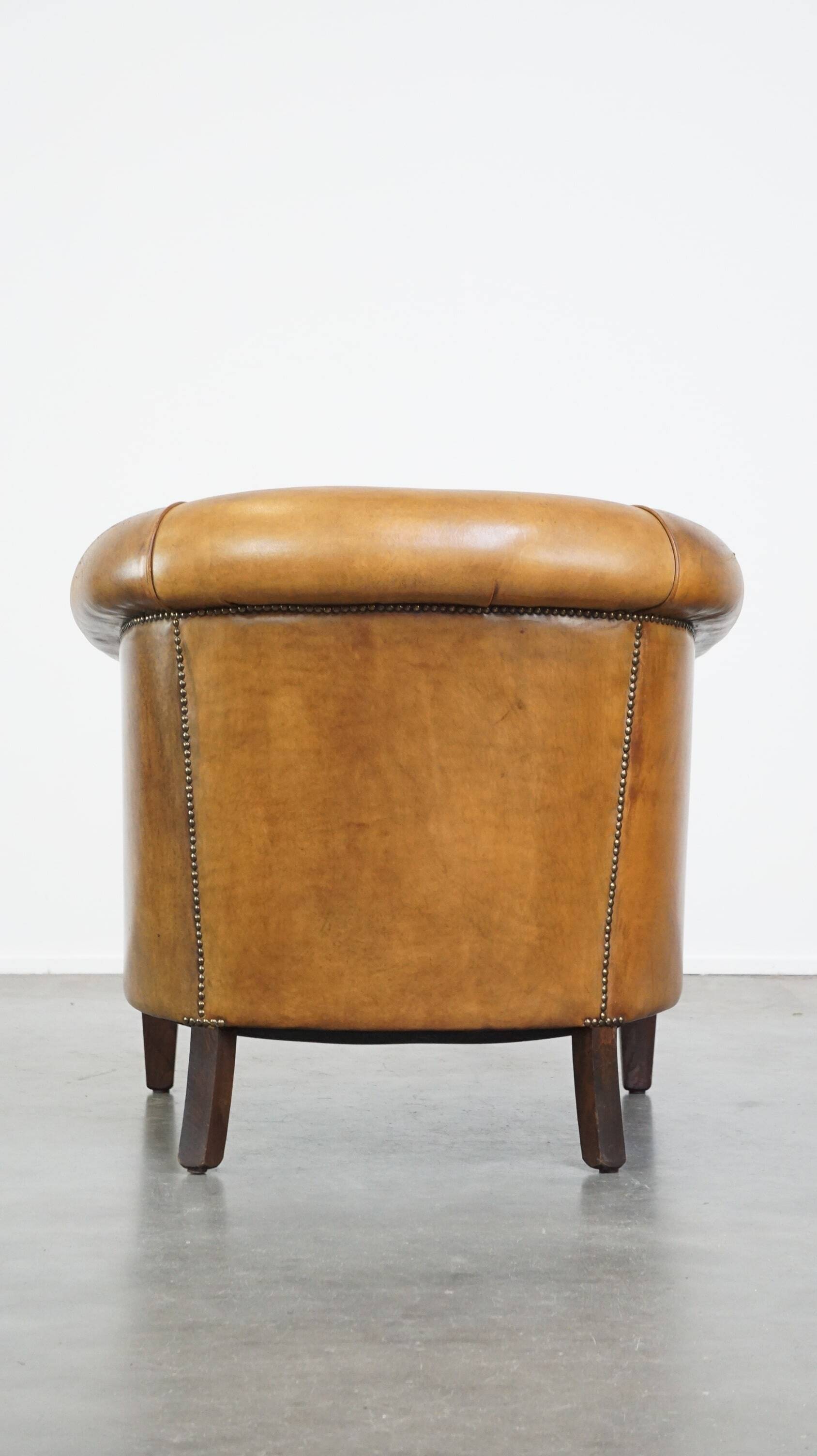 Comfortable, cozy, warm colored sheepskin club chair finished with decorative nails