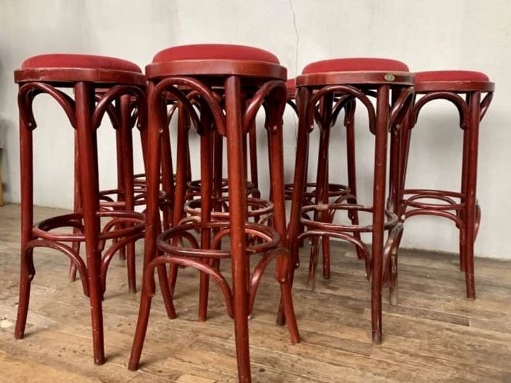 Series of 9 bistro bar stools in curved wooden restaurant sitting red fabric