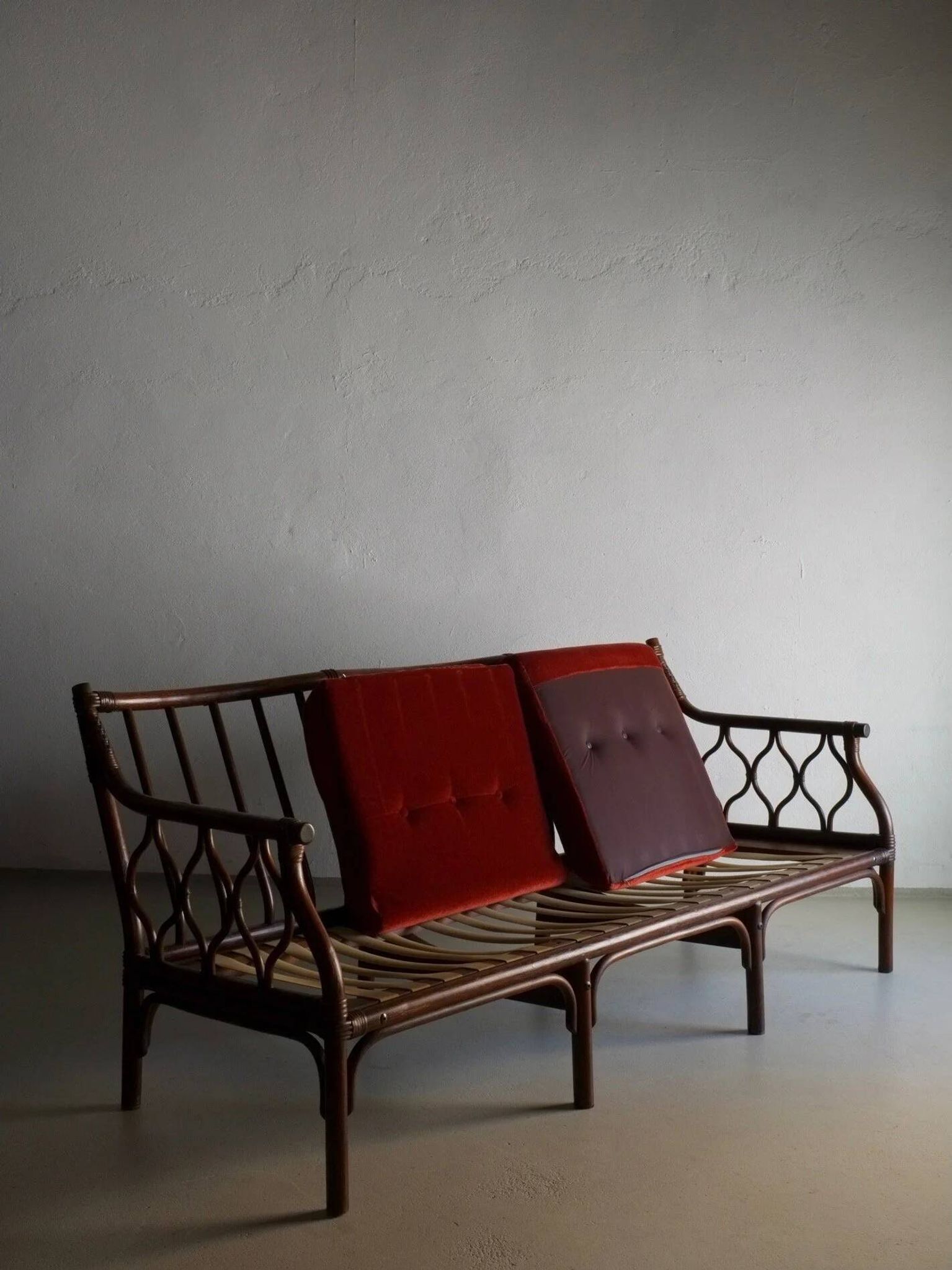 Dark rattan 3-seater sofa with red velour cushions | 1980s
