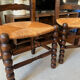 Pair of vintage armchairs with turned wood and woven rope seat.