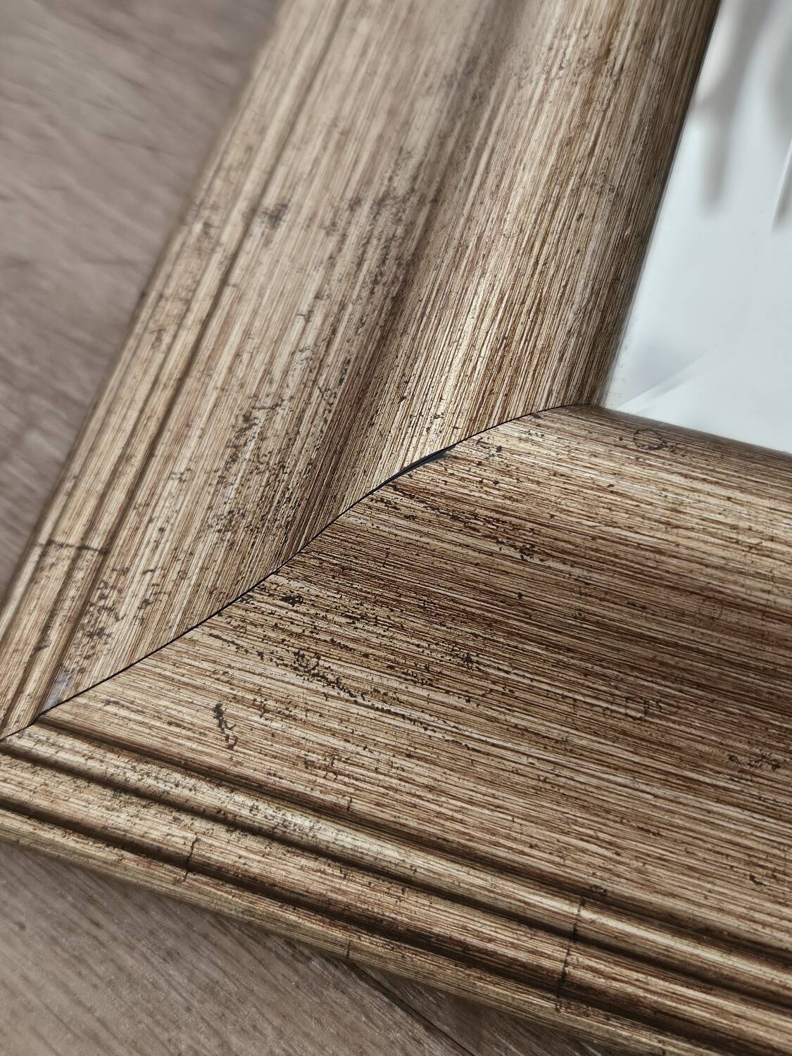 Beveled mirror under gold frame