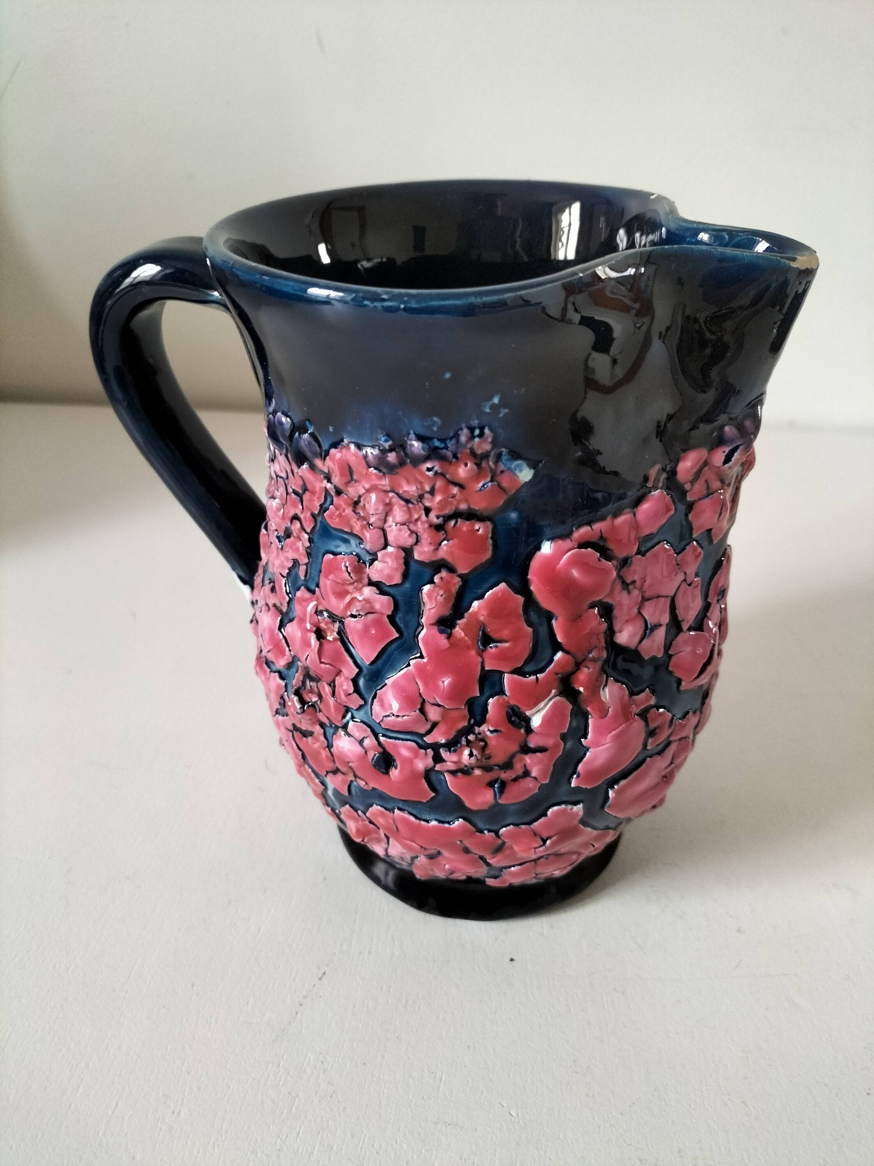 Vintage pitcher in midnight blue glazed ceramic with bright pink relief