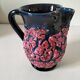 Vintage pitcher in midnight blue glazed ceramic with bright pink relief