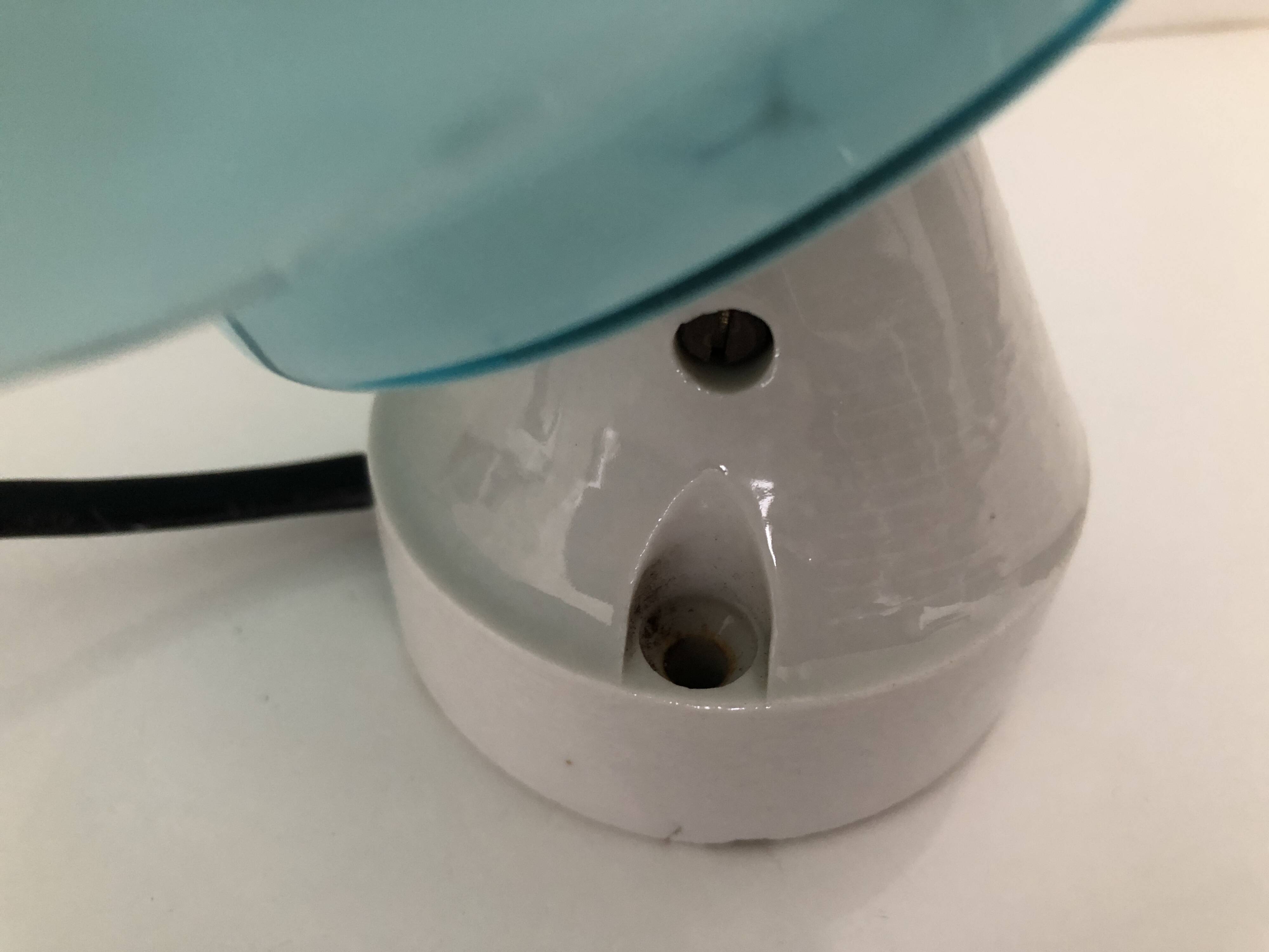 Wall light in ceramic with a light blue glass globe.