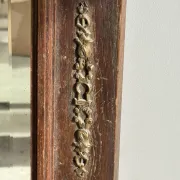Antique mirror door (left) of a brown oak wardrobe with bevelled glass.