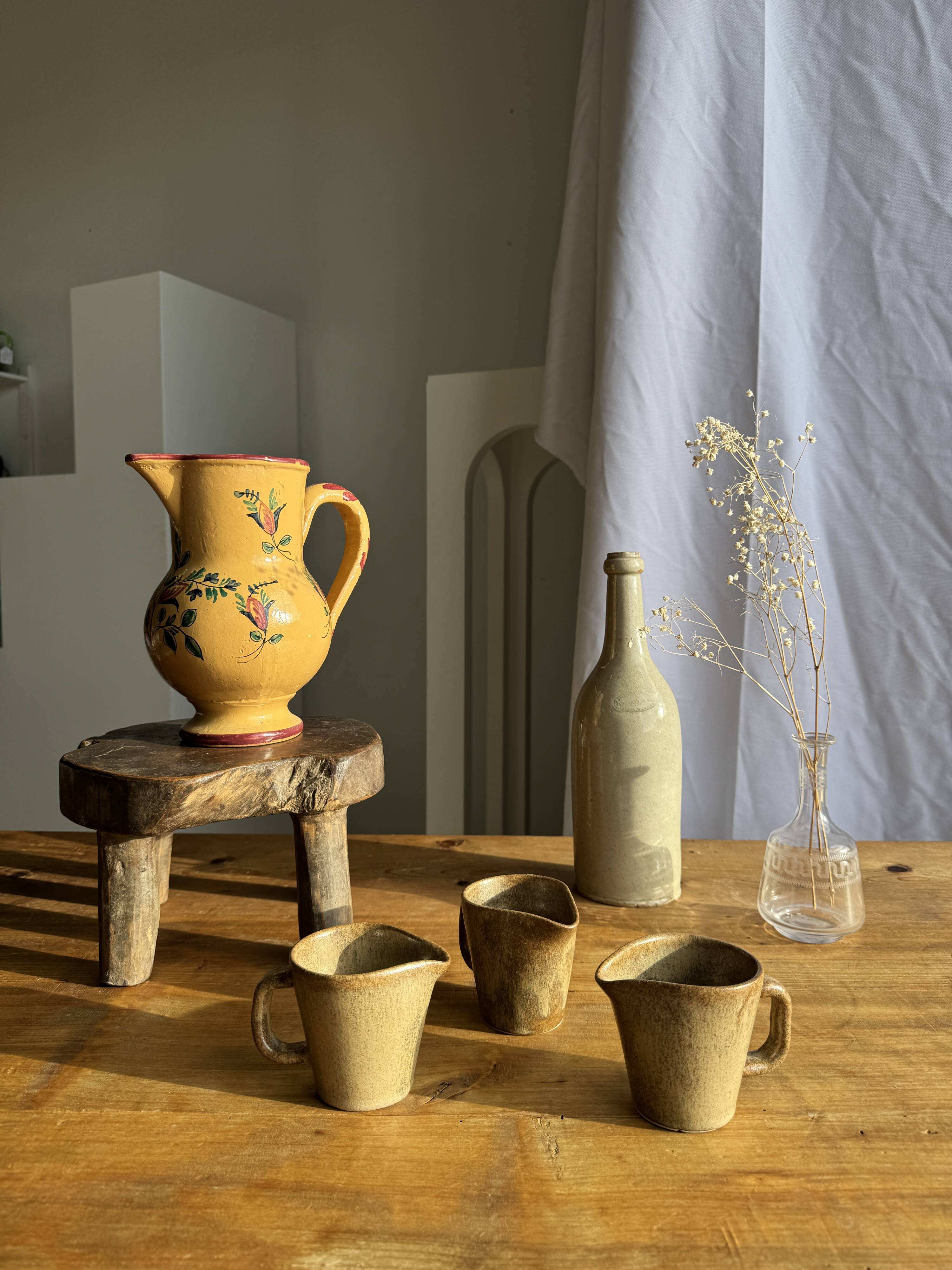 Large antique handmade ochre yellow jug with a pink flower pattern.