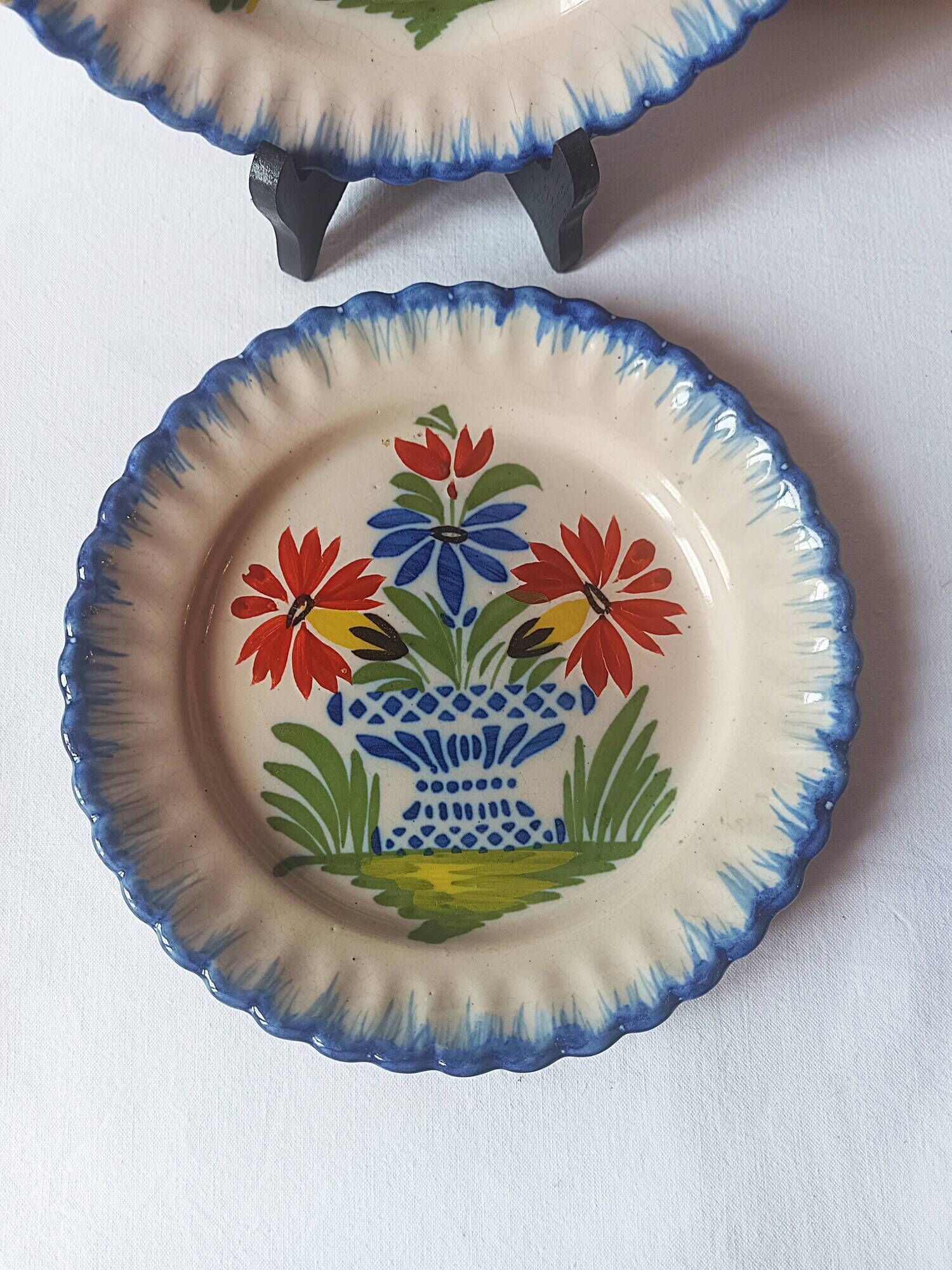 Pair of antique plates in popular earthenware with a floral basket decoration on the edge.