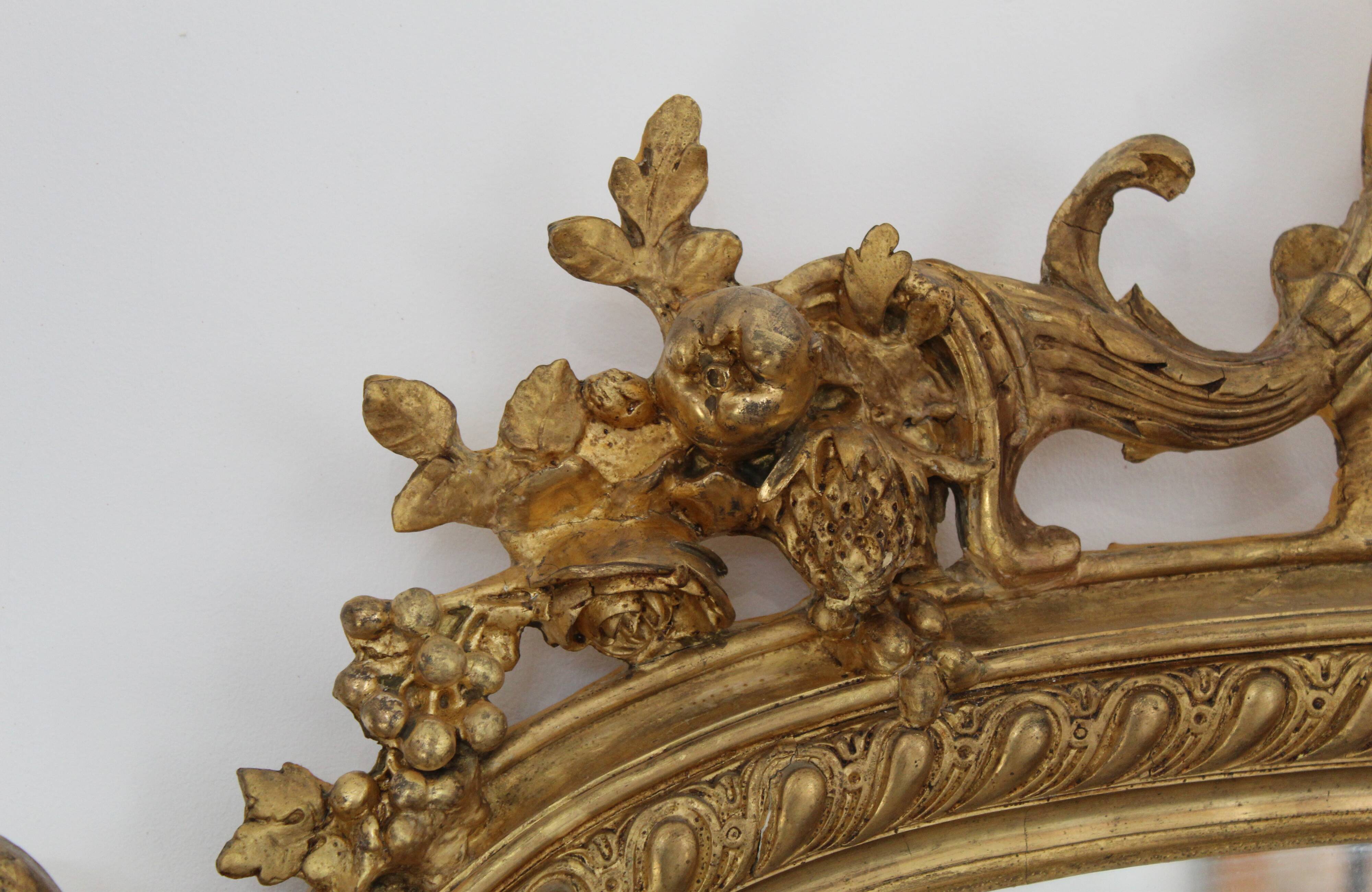Large 19th-century wooden and gilt-studded mirror decorated with a cornucopia motif.