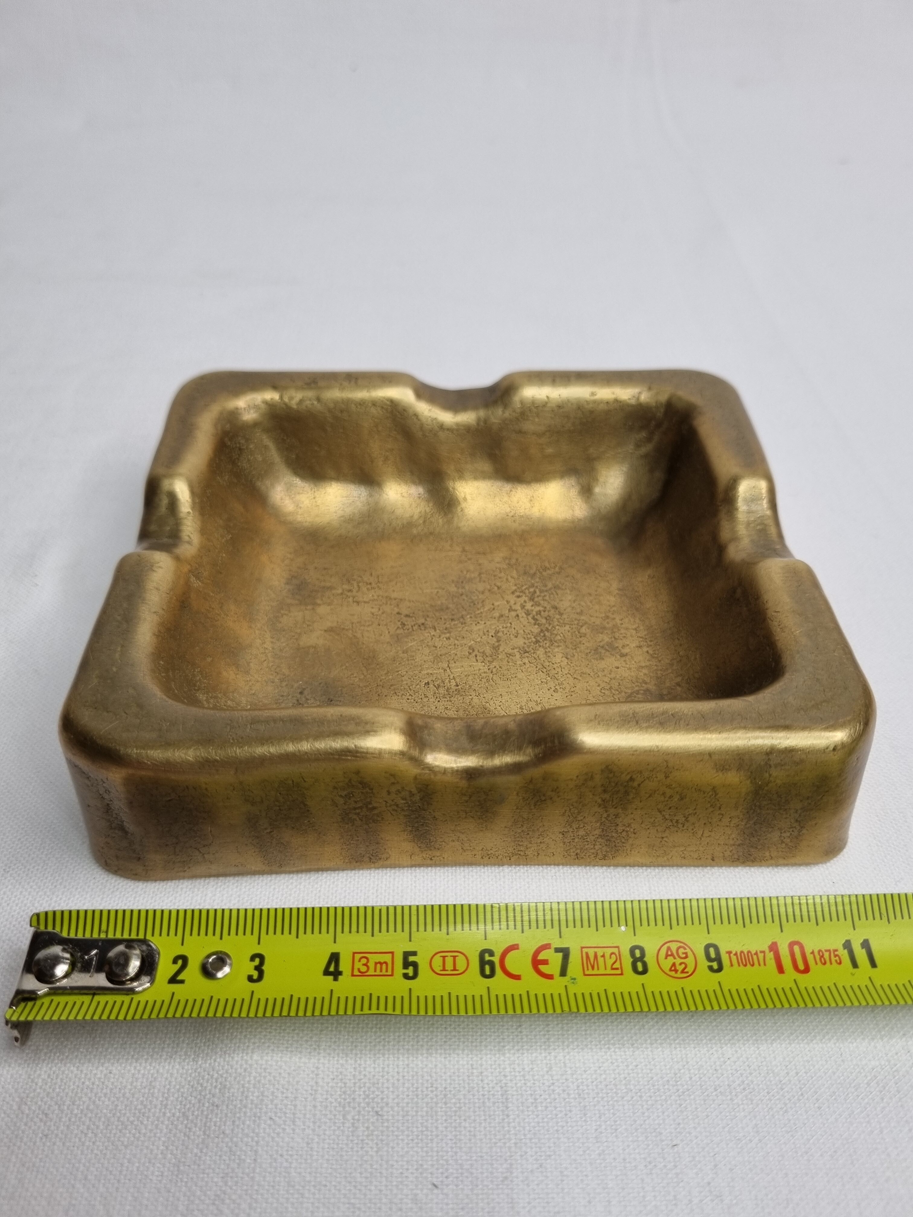 Empty pocket brutalist-inspired ashtray in gilded bronze