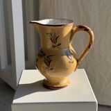 Large antique handmade ochre yellow jug with a pink flower pattern.