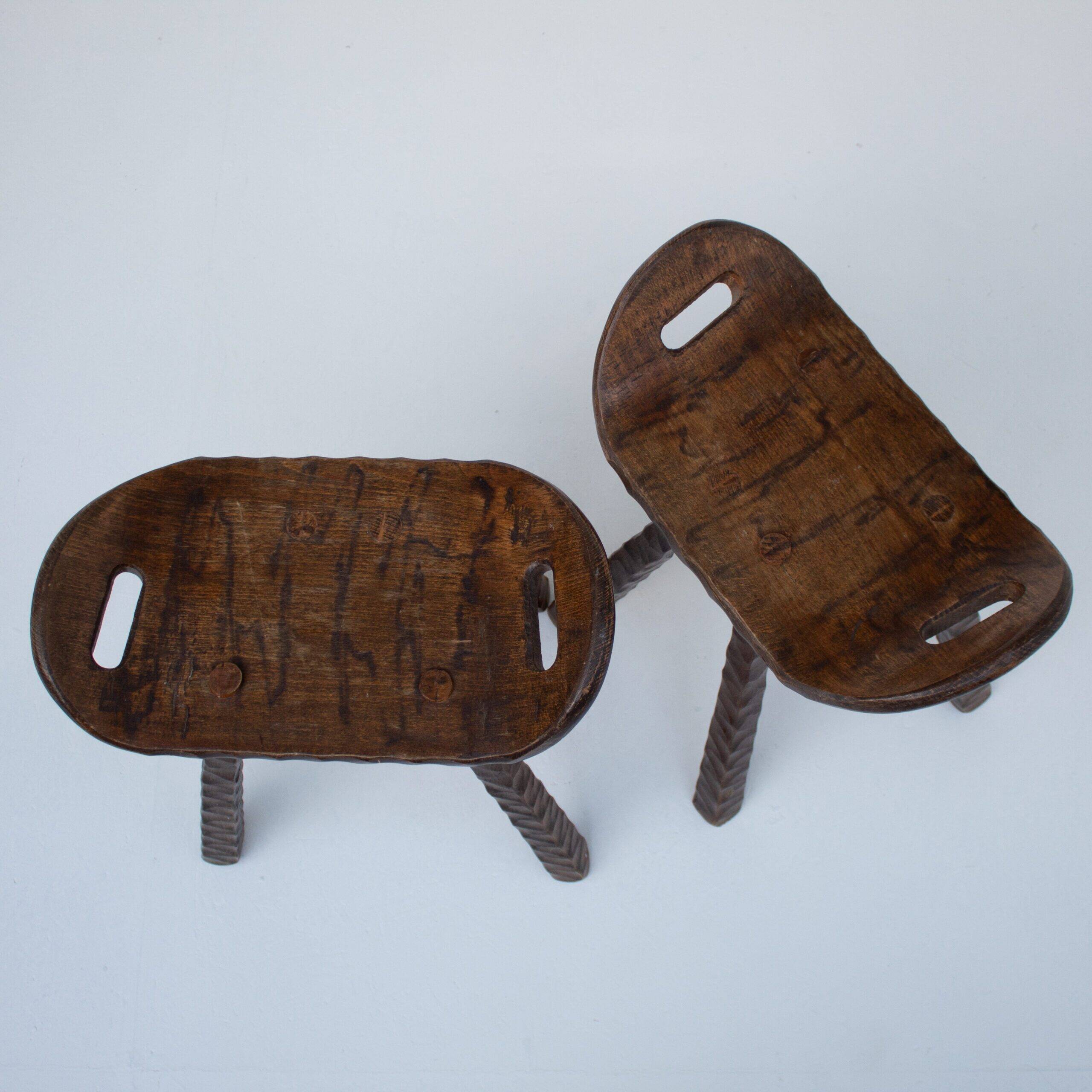 Ensemble de deux tabourets en bois sculptés à la main avec poignées.