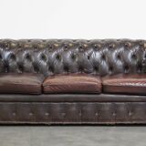 Old dark brown 3-seater cowhide chesterfield sofa with lots of character