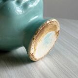 Turquoise plant pot in the shape of a vintage doll's head.