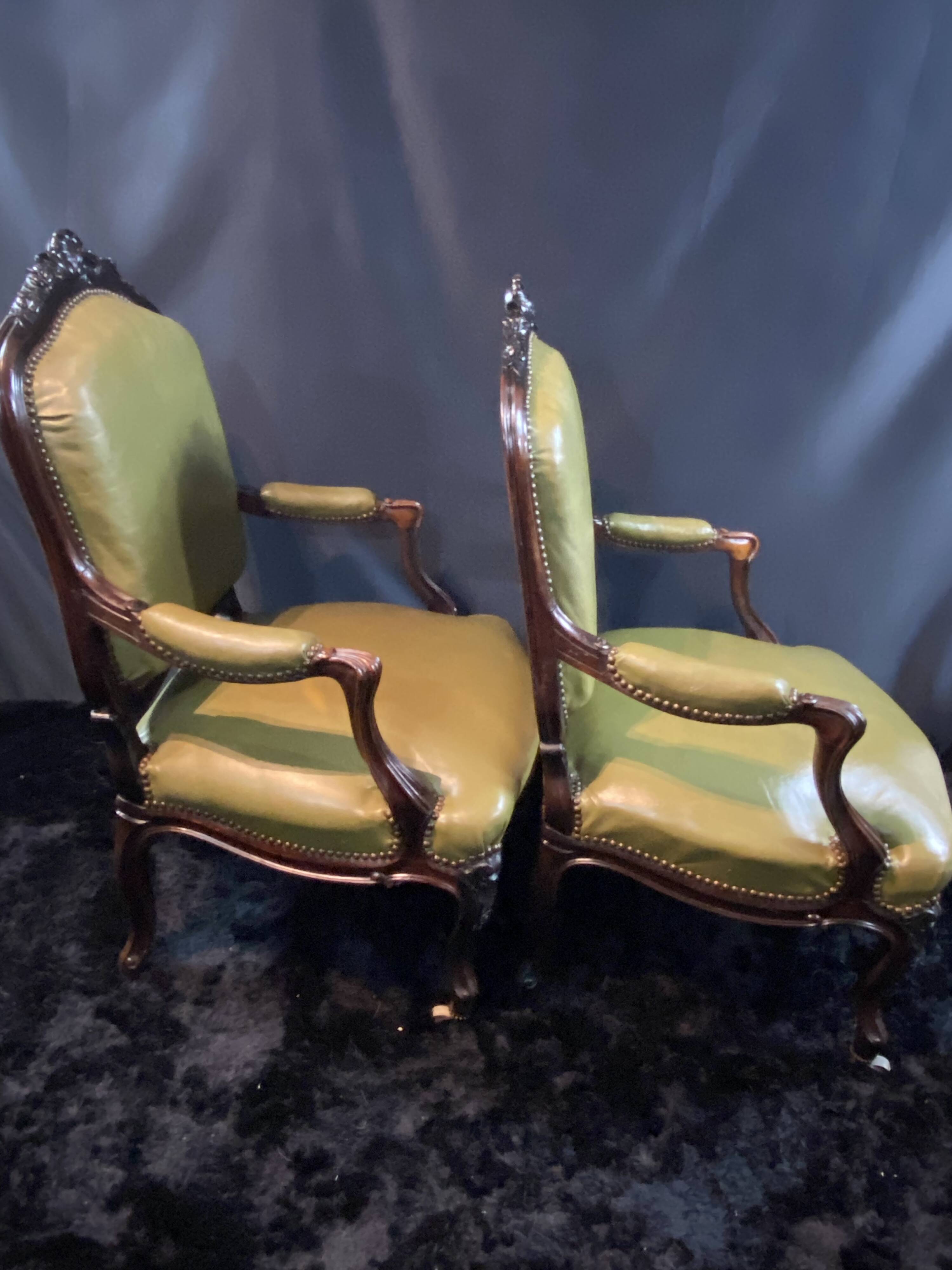 Paire de larges fauteuils XIXe en cuir vert de style Louis XV
