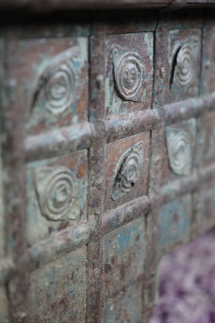 Low chest with metal closure and top opening.