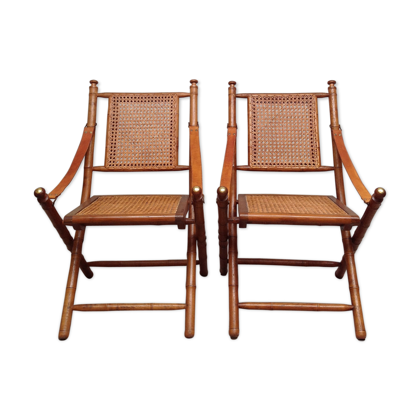 Pair of folding chairs in bamboo and caning, leather and brass