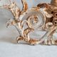 Wall lamp in antique cast iron with bird and scroll decorations.