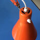 Luxo L9 orange single-arm lamp on plinth