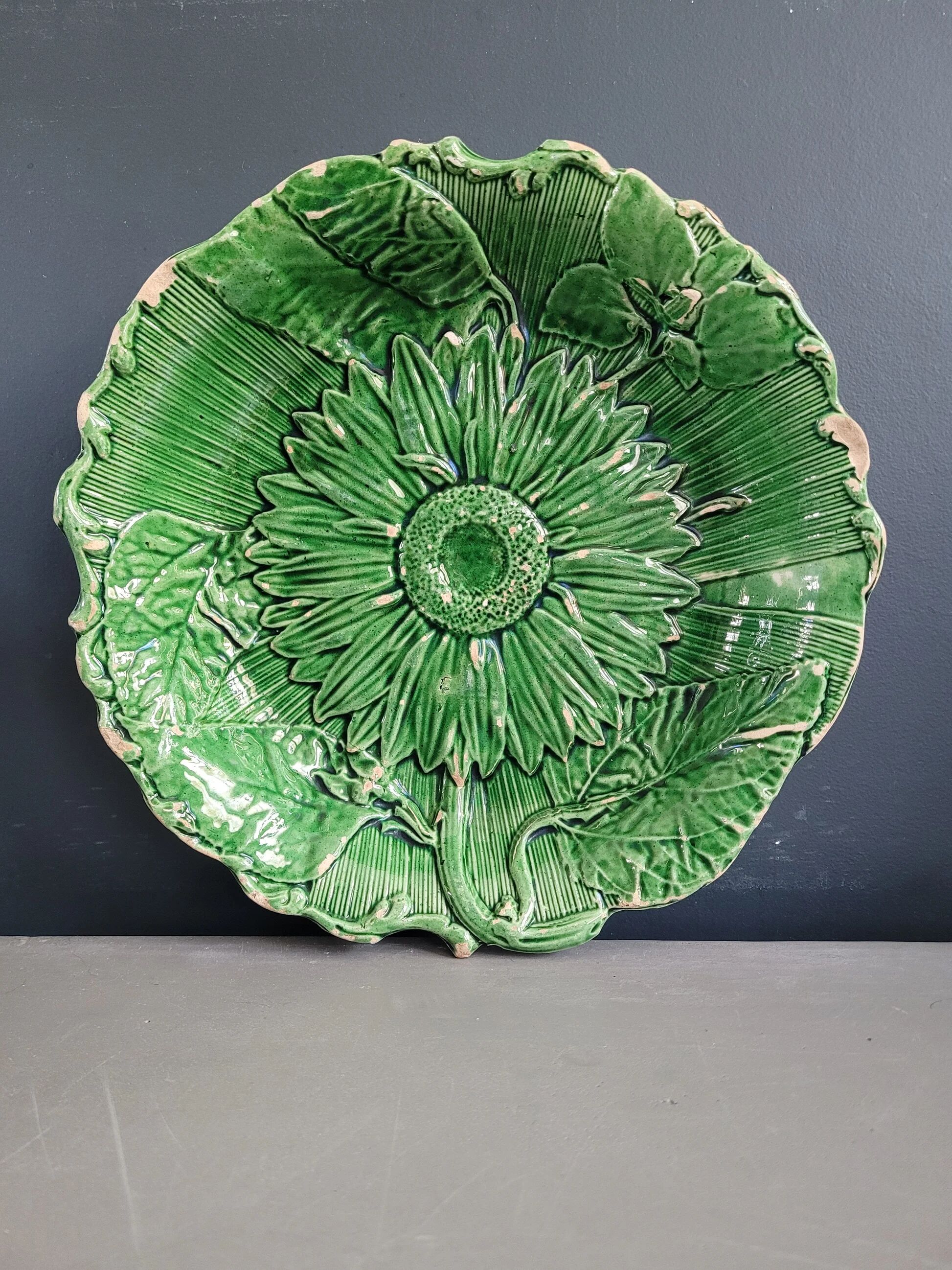 Plate decorated with a sunflower motif in slipware.