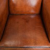 Wingback chair made of sheep leather with black piping in good condition