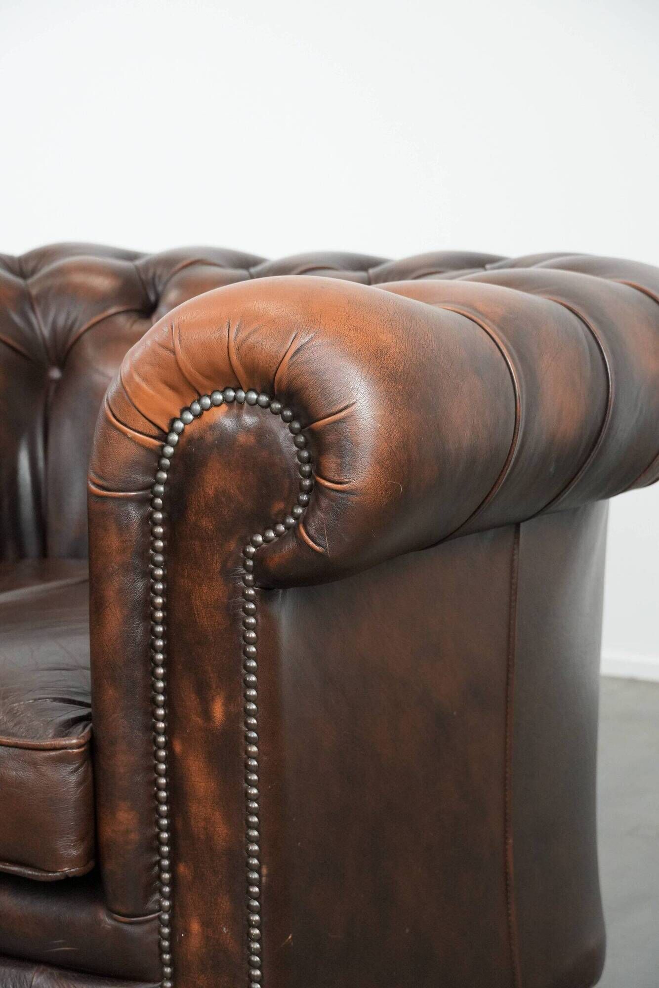 Brown Chesterfield armchair made of cowhide leather in English style