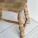 Antique wooden stool with four turned legs.
