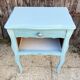 Pair of patinated lagoon blue bedside tables, early 20th century, with curved legs.