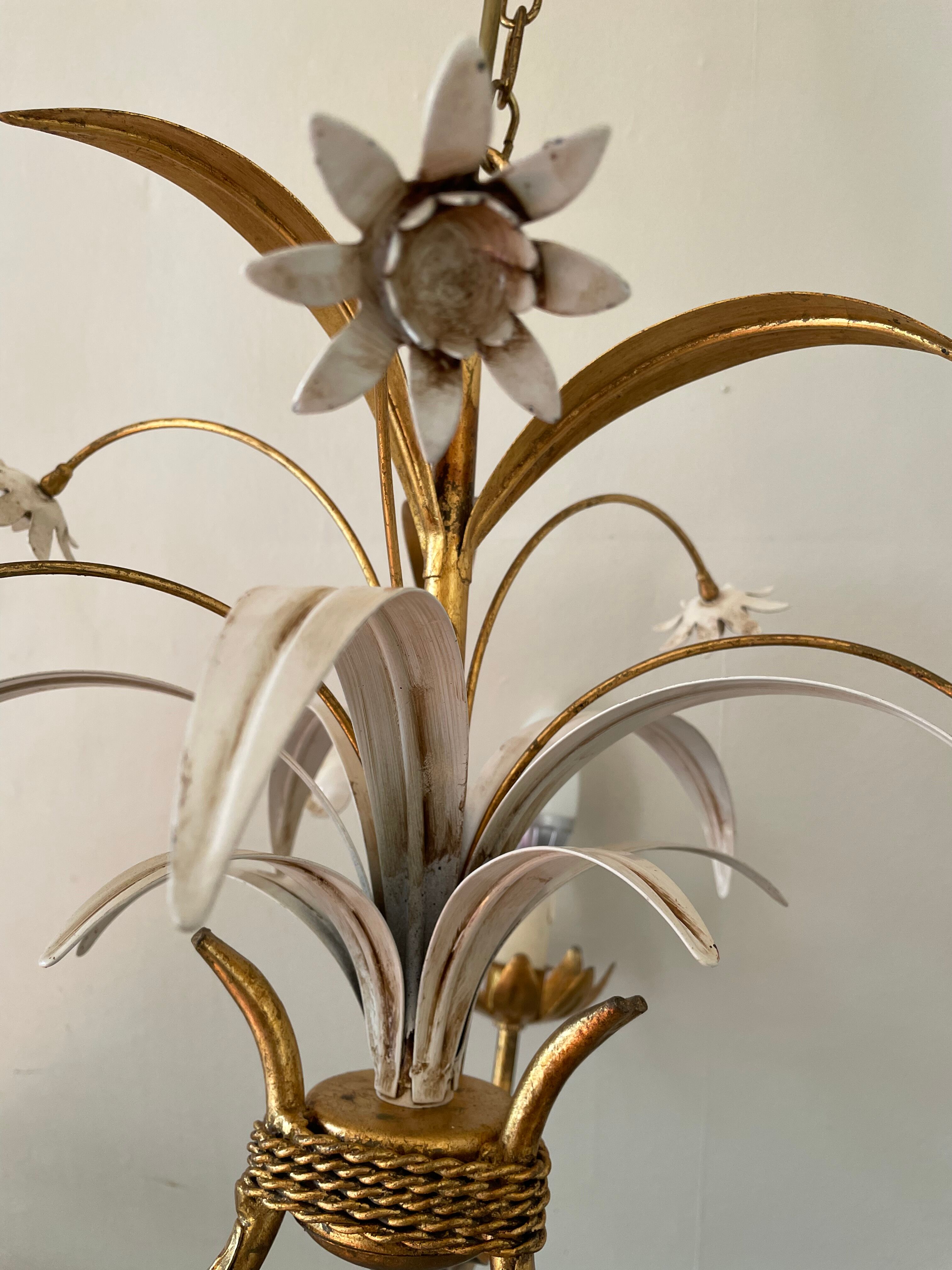 Golden metal chandelier decorated with flowers