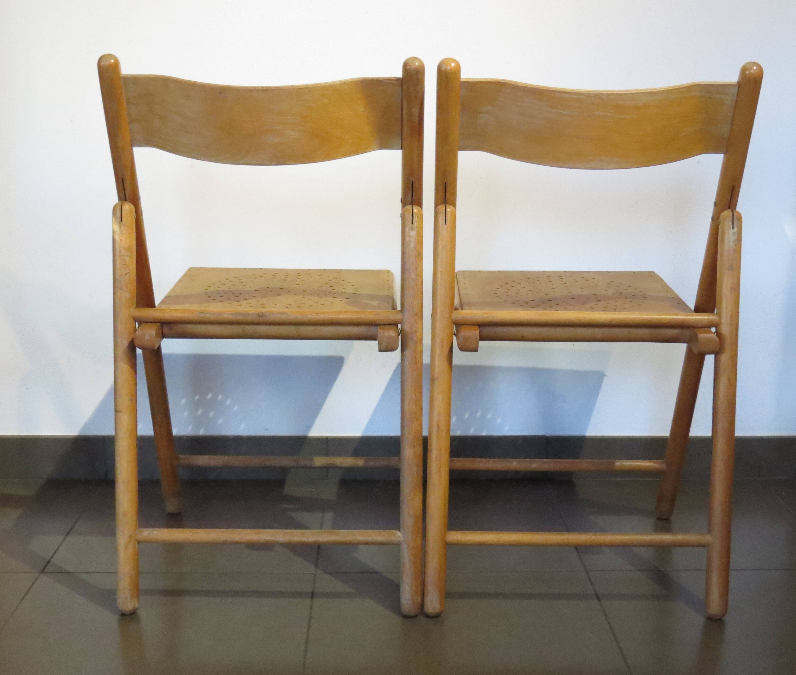 Pair of vintage wooden folding chairs with star pattern on seat