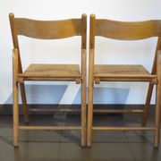 Pair of vintage wooden folding chairs with star pattern on seat