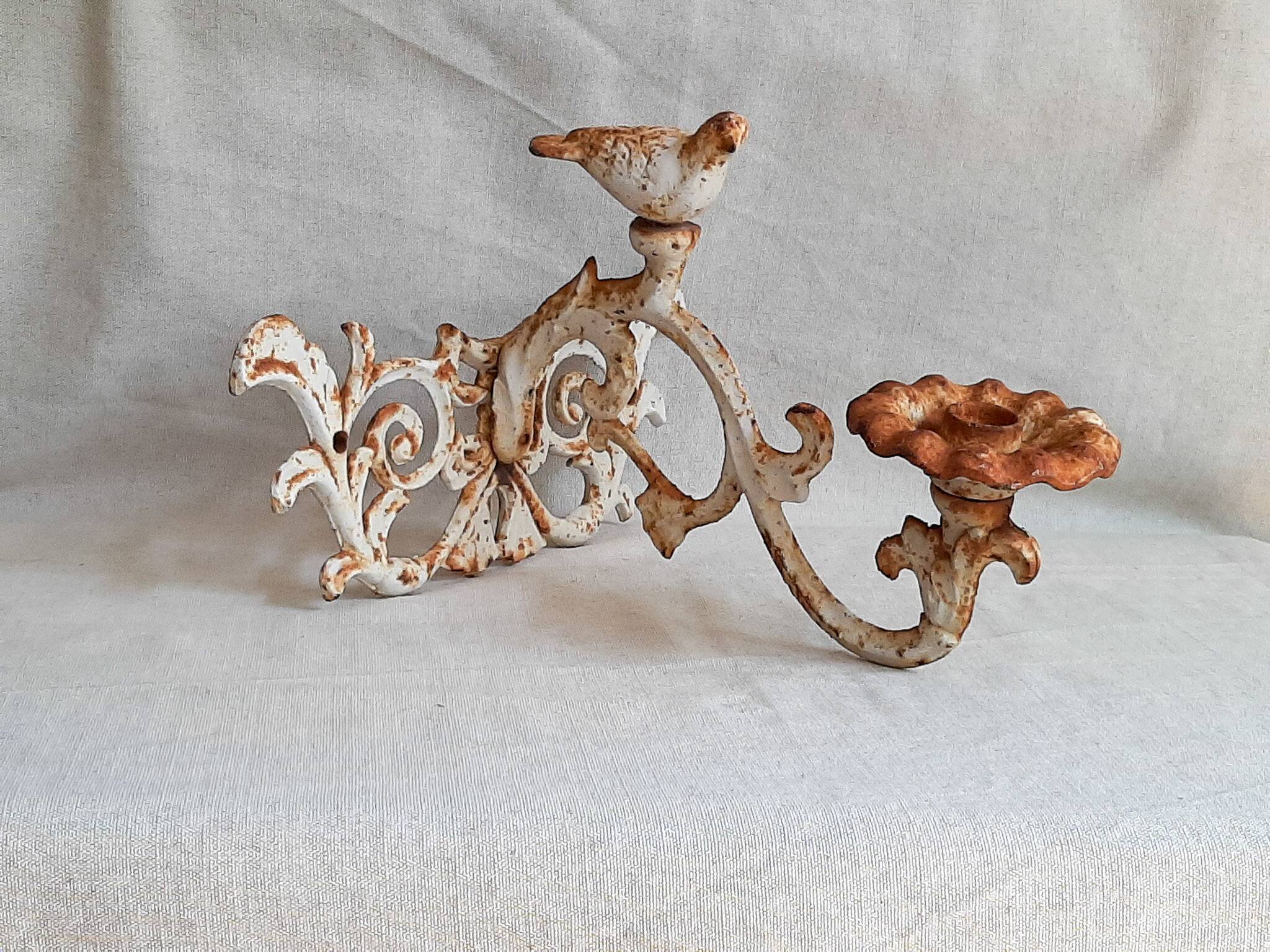 Wall lamp in antique cast iron with bird and scroll decorations.