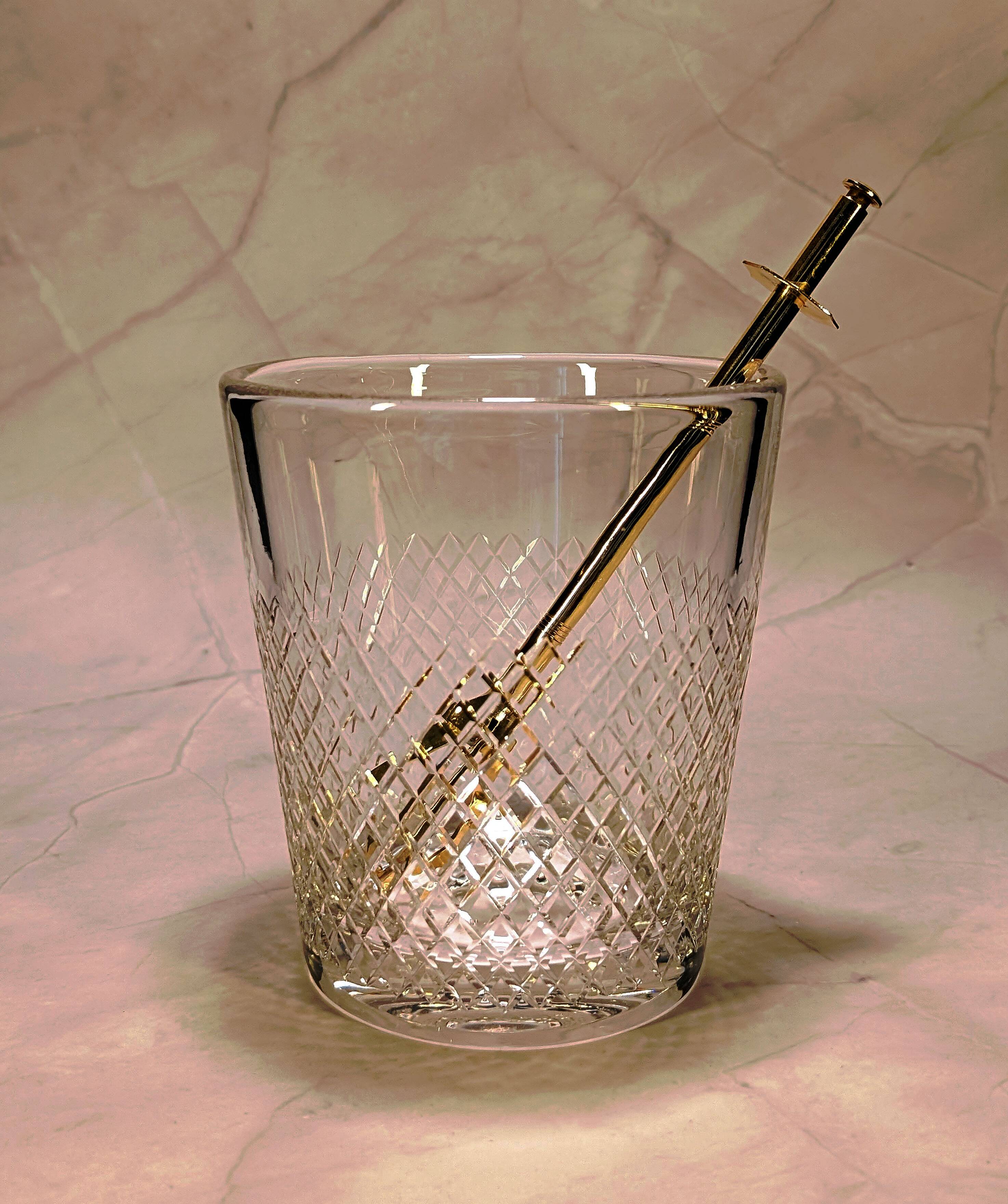 Vintage crystal ice bucket with gold tongs.