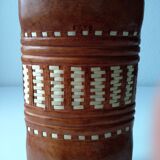 Vintage glass bottle covered with light brown leather and wicker