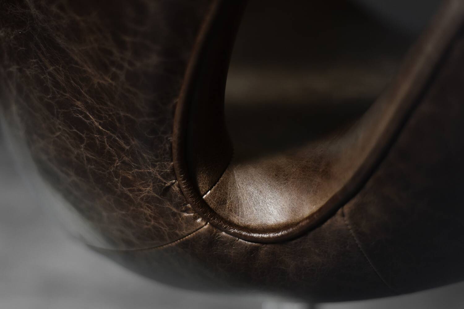 Brown leather Swan chair by Arne Jacobsen, mid-century Danish modernity.