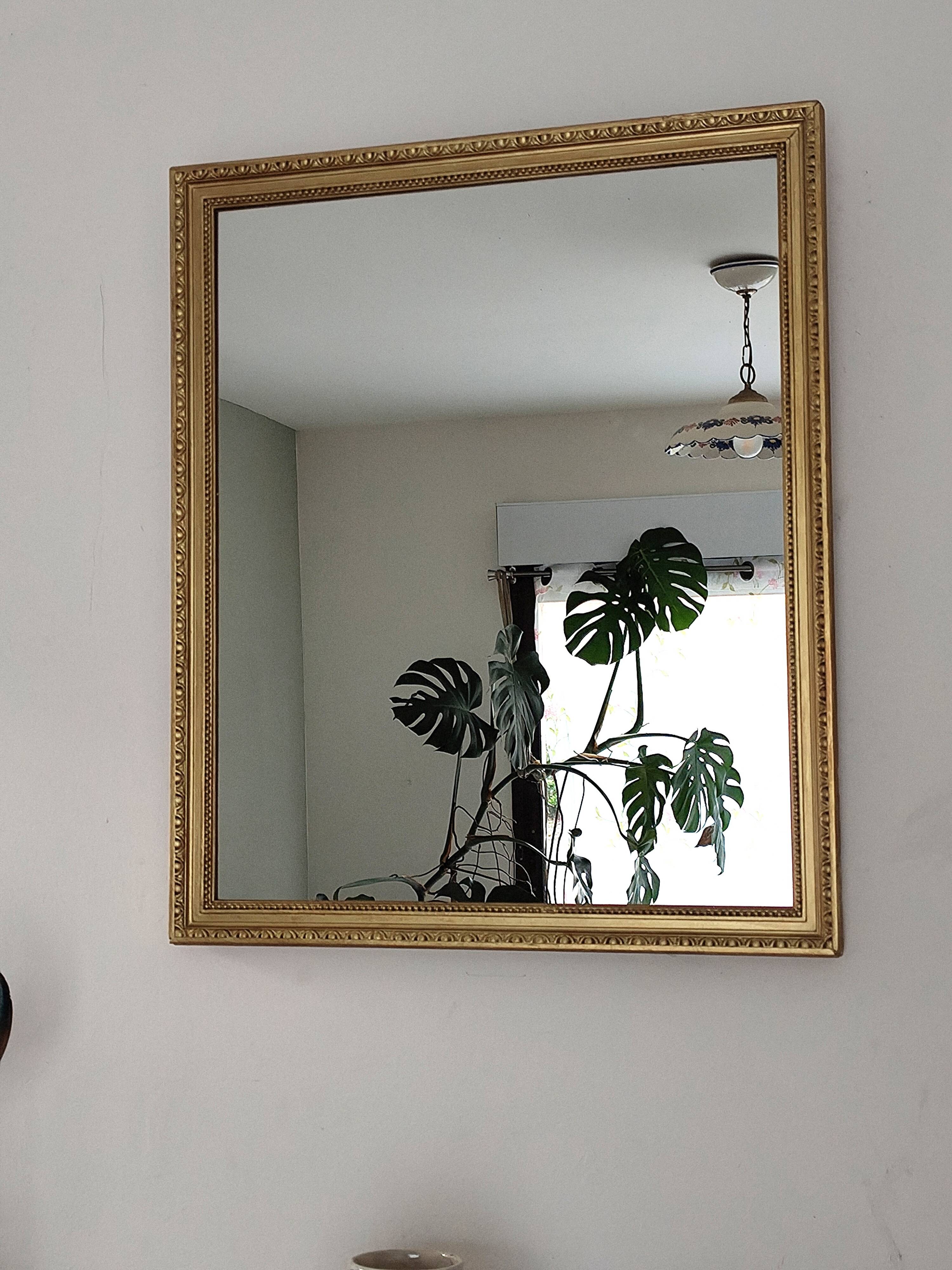 Antique mirror with a gilded frame and beaded border.