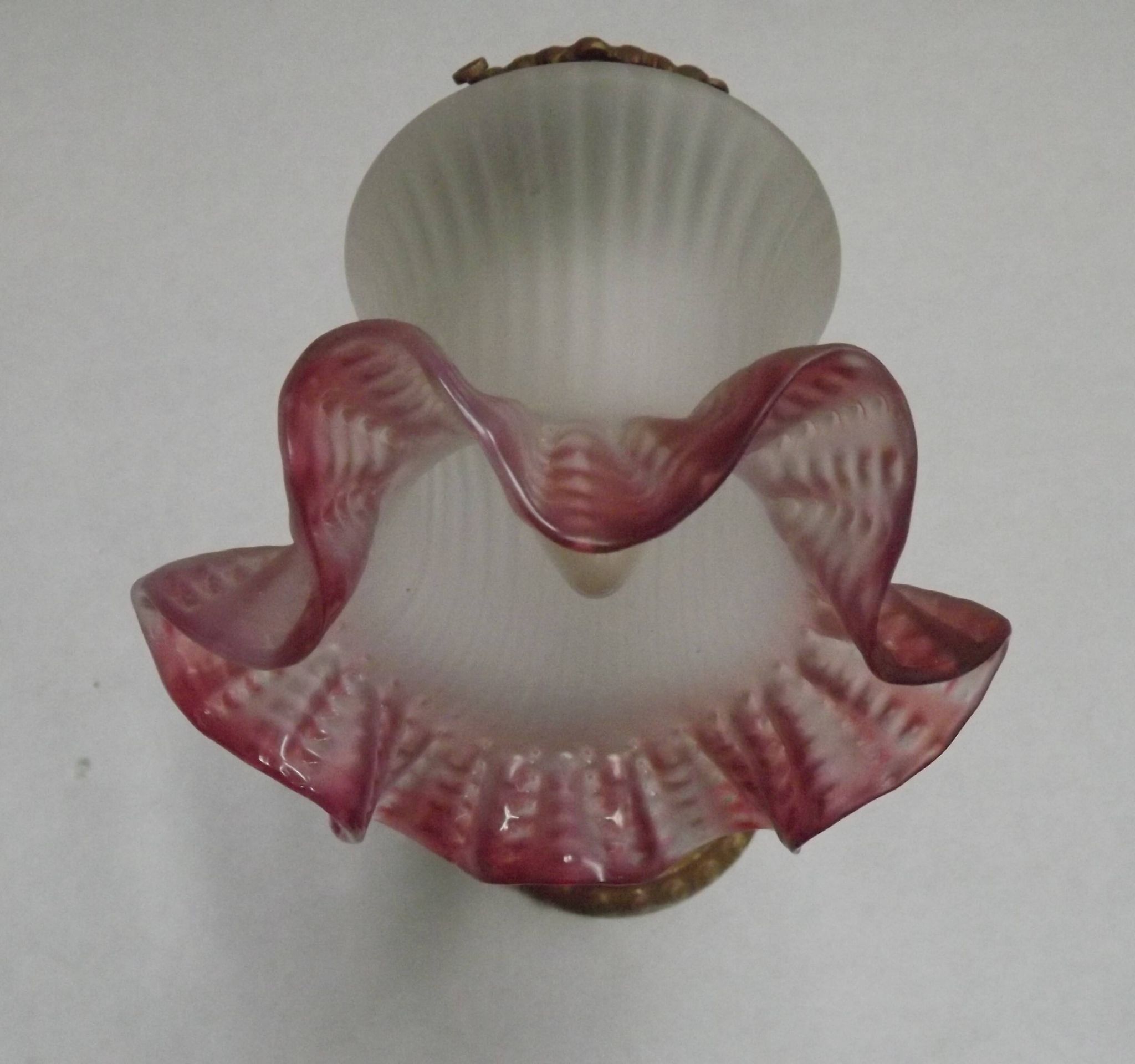 French Art Nouveau wall sconce in bronze with a white and pink glass shade.