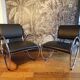 Pair of chrome and faux leather armchairs
