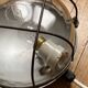 Industrial porthole wall light in Bakelite with glass globe.