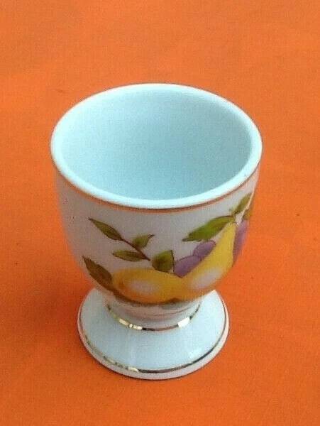 White porcelain egg cup decorated with pears / grapes.