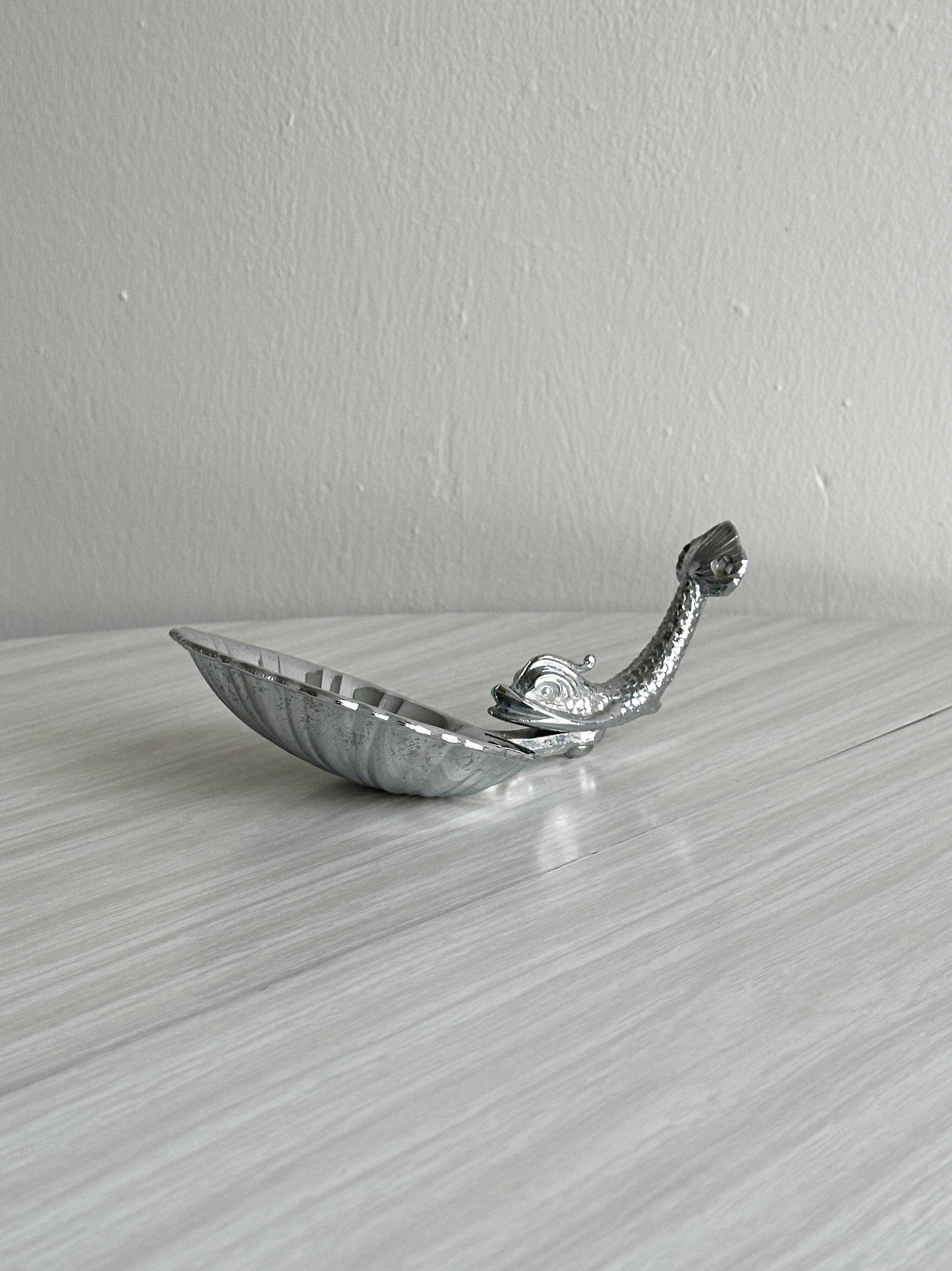 Soap dish, shell-shaped lightweight metal catchall.