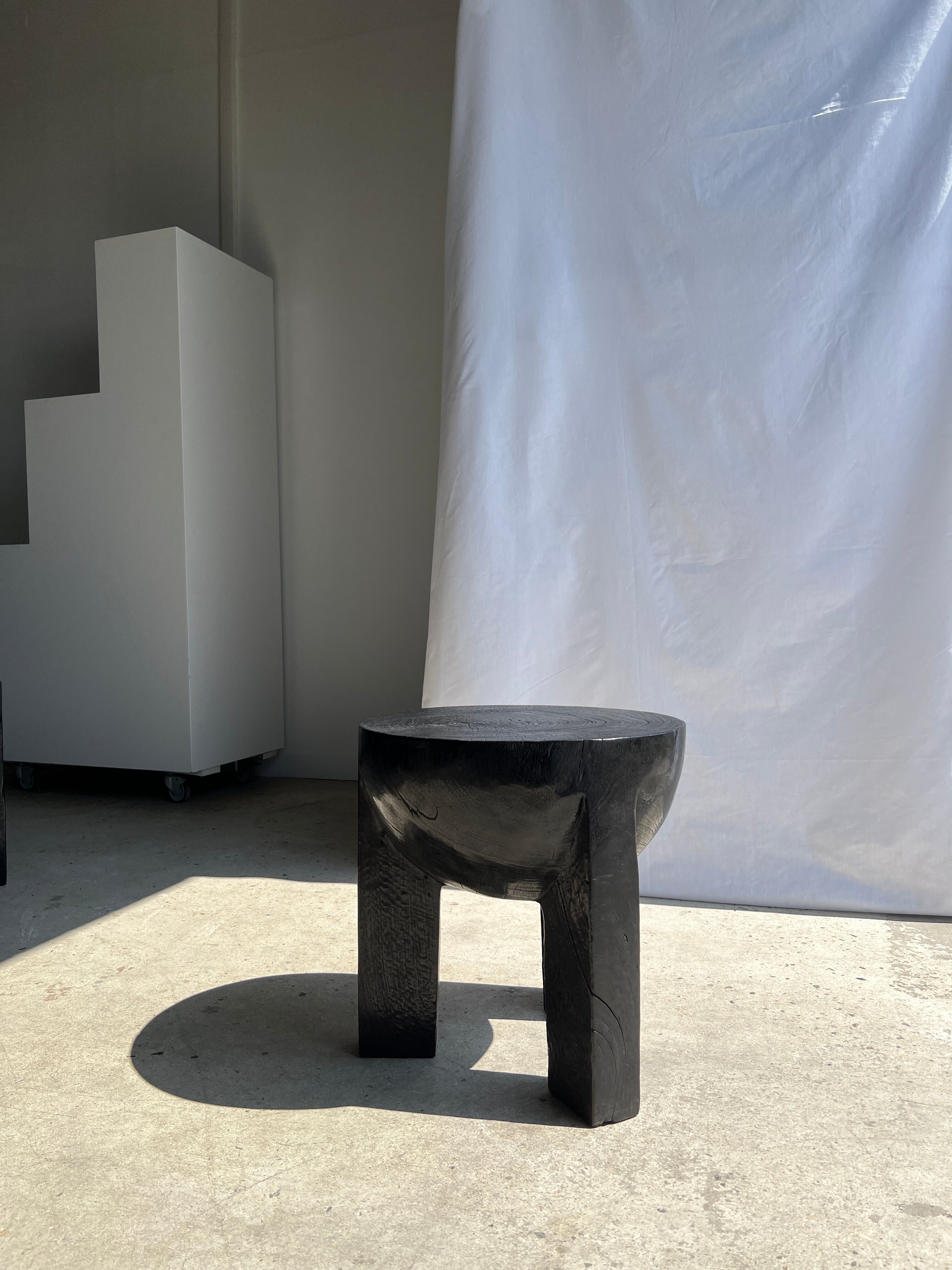 Black mango wood tripod side table with a semi-spherical top, height: 45 cm, diameter: 44 cm.