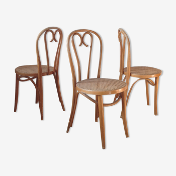 3 curved wooden chairs and cannage