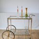 Serving table in gilded metal and glass with large wheels 1950
