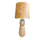 Large beige ceramic table lamp with a vintage shade.