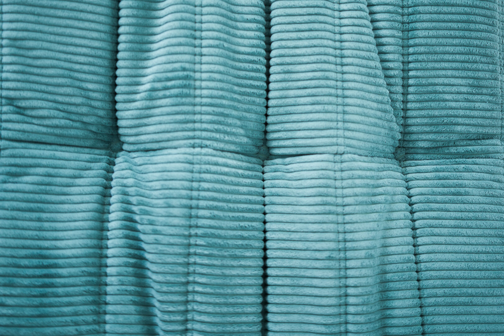 Ensemble de fauteuil et pouf Togo en velours côtelé bleu clair.