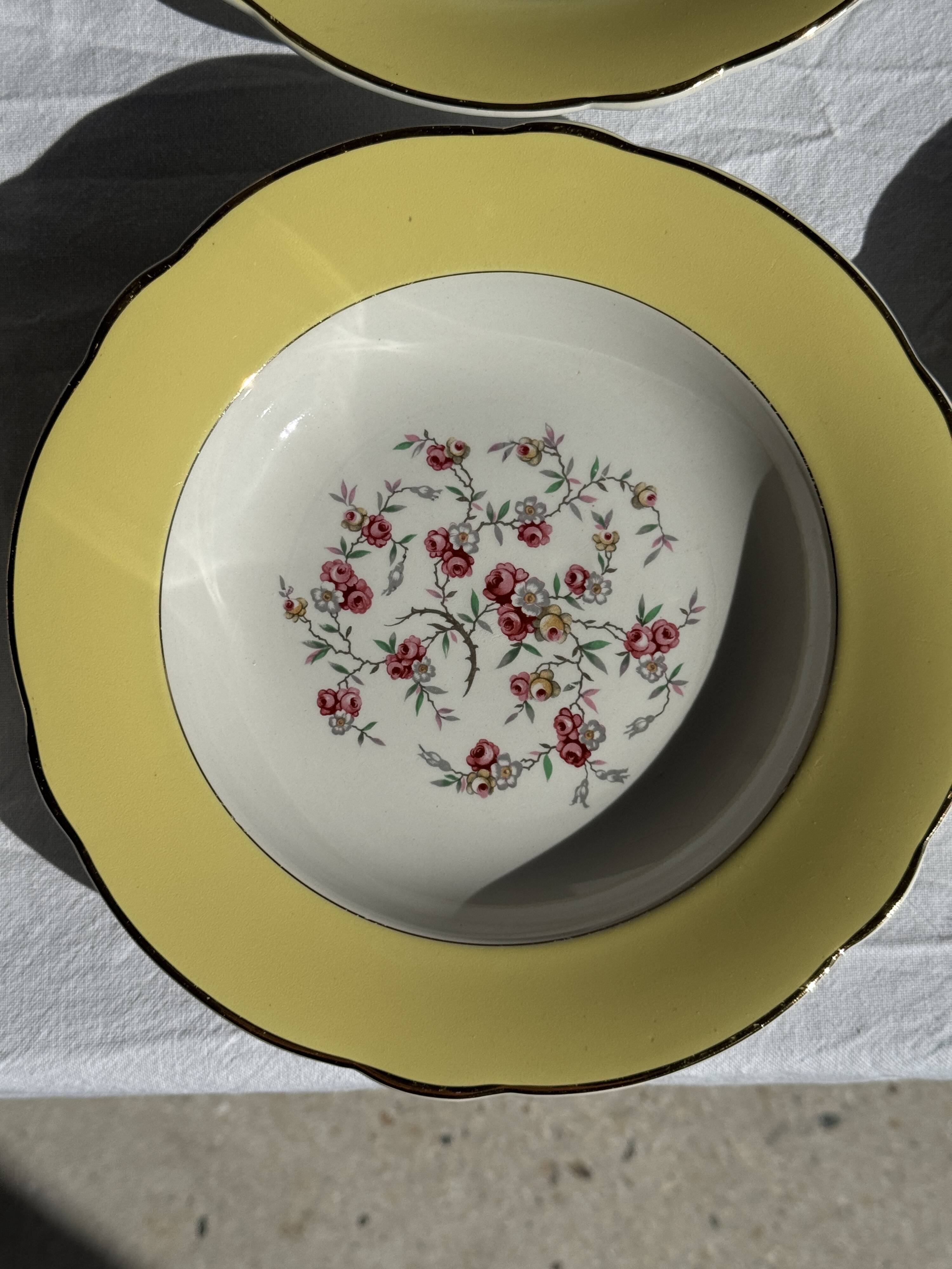 Set of 9 large vintage yellow deep plates with pink flowers and a gold rim.