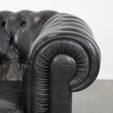 Comfortable black chesterfield armchair made of cowhide leather