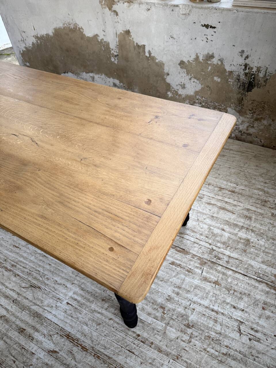 Oak farmhouse table with turned black legs.