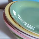 Seven pastel-colored plates mixed with vintage earthenware