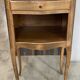 A bedside table with a drawer and a niche in Louis XV style.